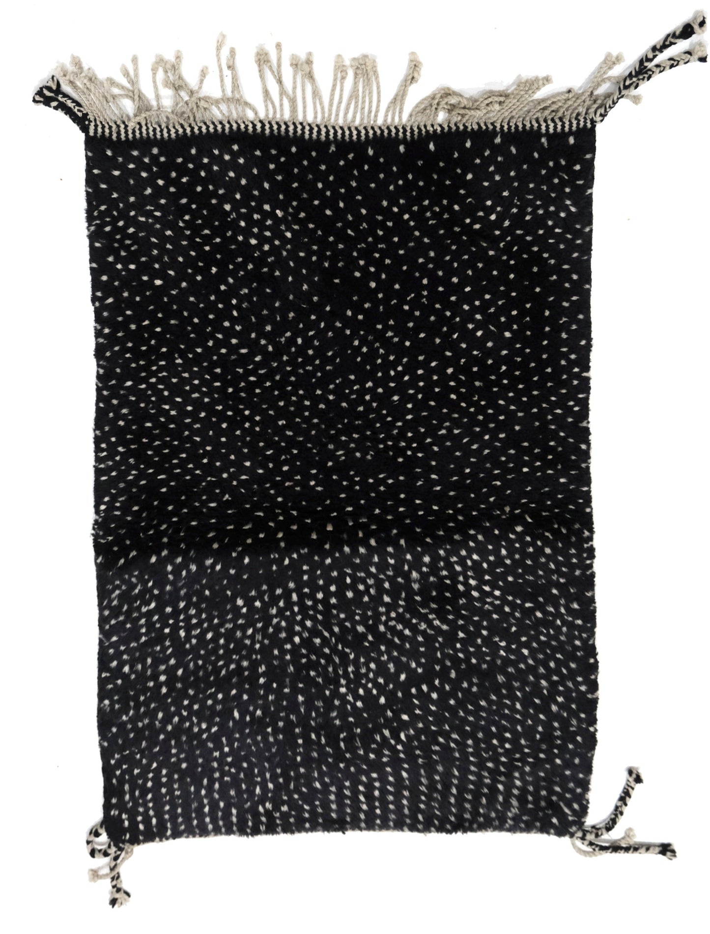 Hand-loomed black wool area rug featuring a speckled white-and-cream confetti texture, with a chunky top fringe and braided corner tassel ties, displayed on a white background.

