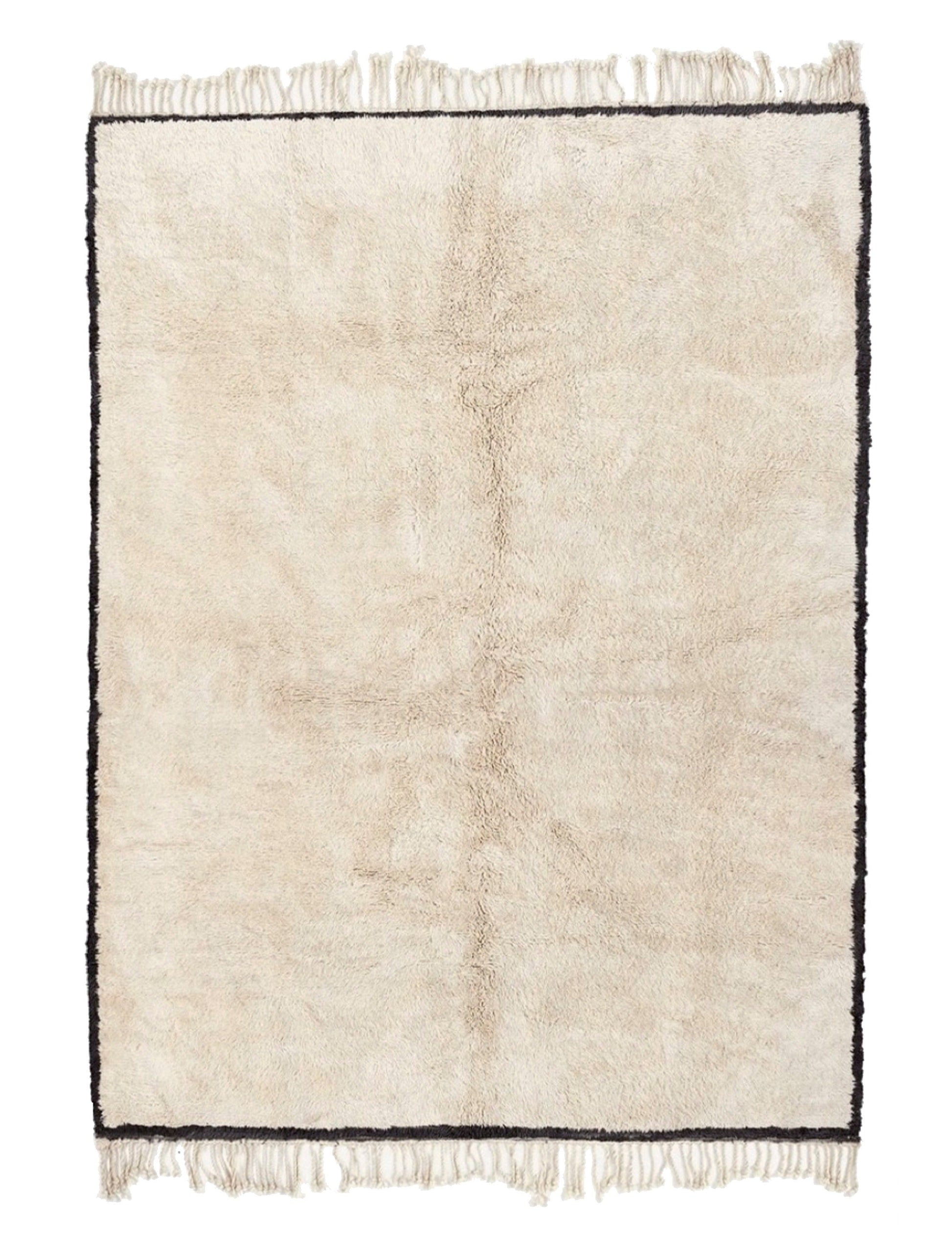 Plush cream wool rug featuring a thin black border framing the entire perimeter, a subtle vertical central seam, and knotted fringed edges on both the top and bottom, displayed on a white background.