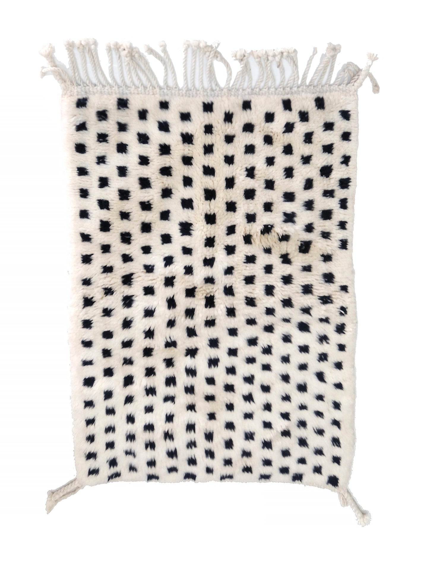 Plush cream wool rug with a grid of raised, fuzzy black tufted dots, featuring a chunky twisted top fringe and small braided corner ties, displayed on a white background.

