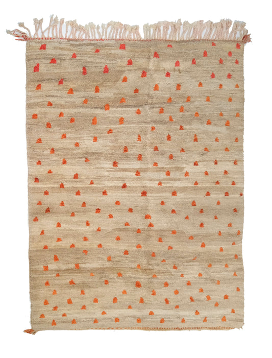 Plush hand-knotted taupe and camel wool rug featuring a subtle central seam and a scatter of vibrant orange and rust-colored primitive tribal symbols, with a twisted top fringe and small braided corner ties, displayed on a white background.