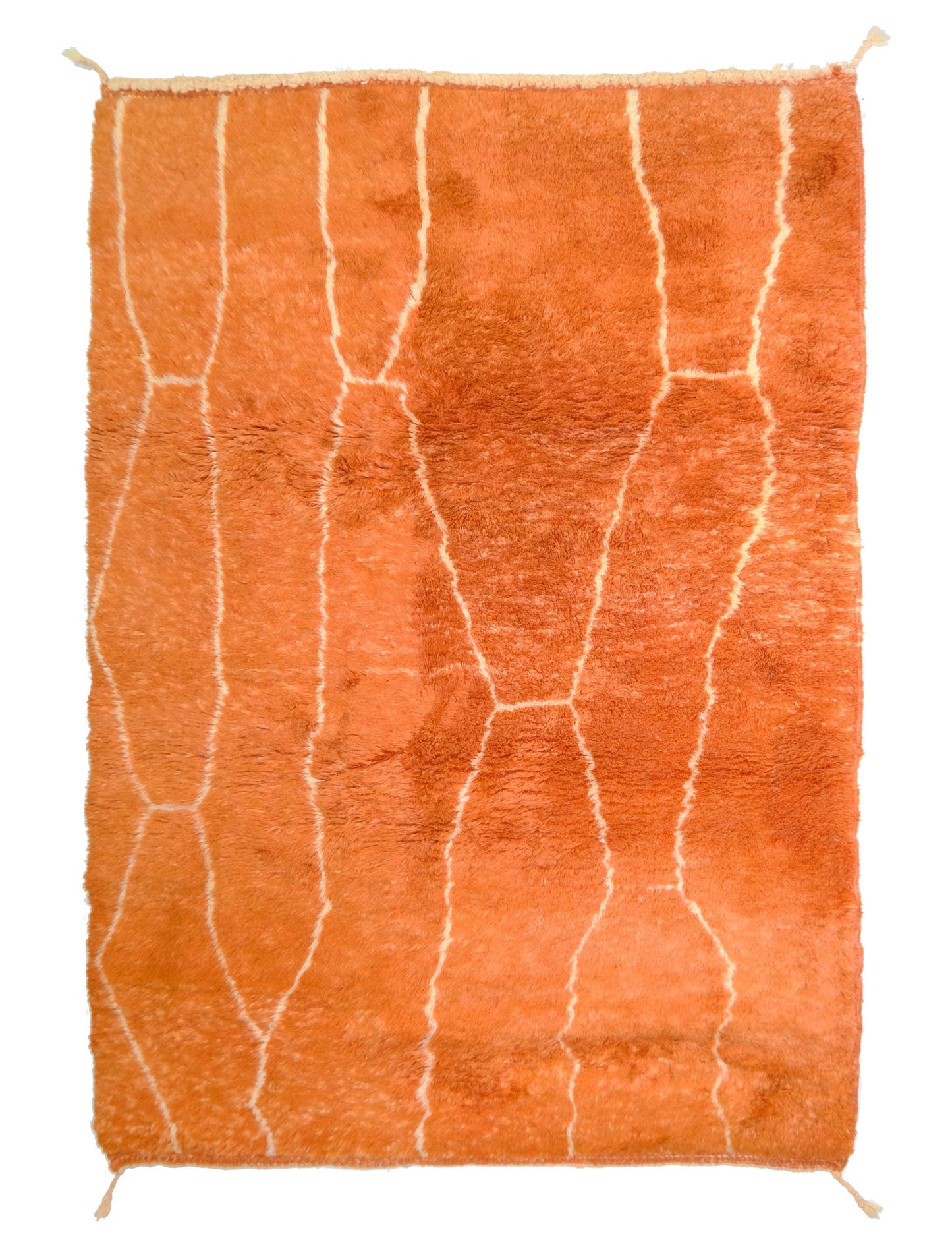 Plush burnt orange high-pile wool rug with a cream organic lattice pattern, top fringe, and small corner ties, displayed on a white background.
