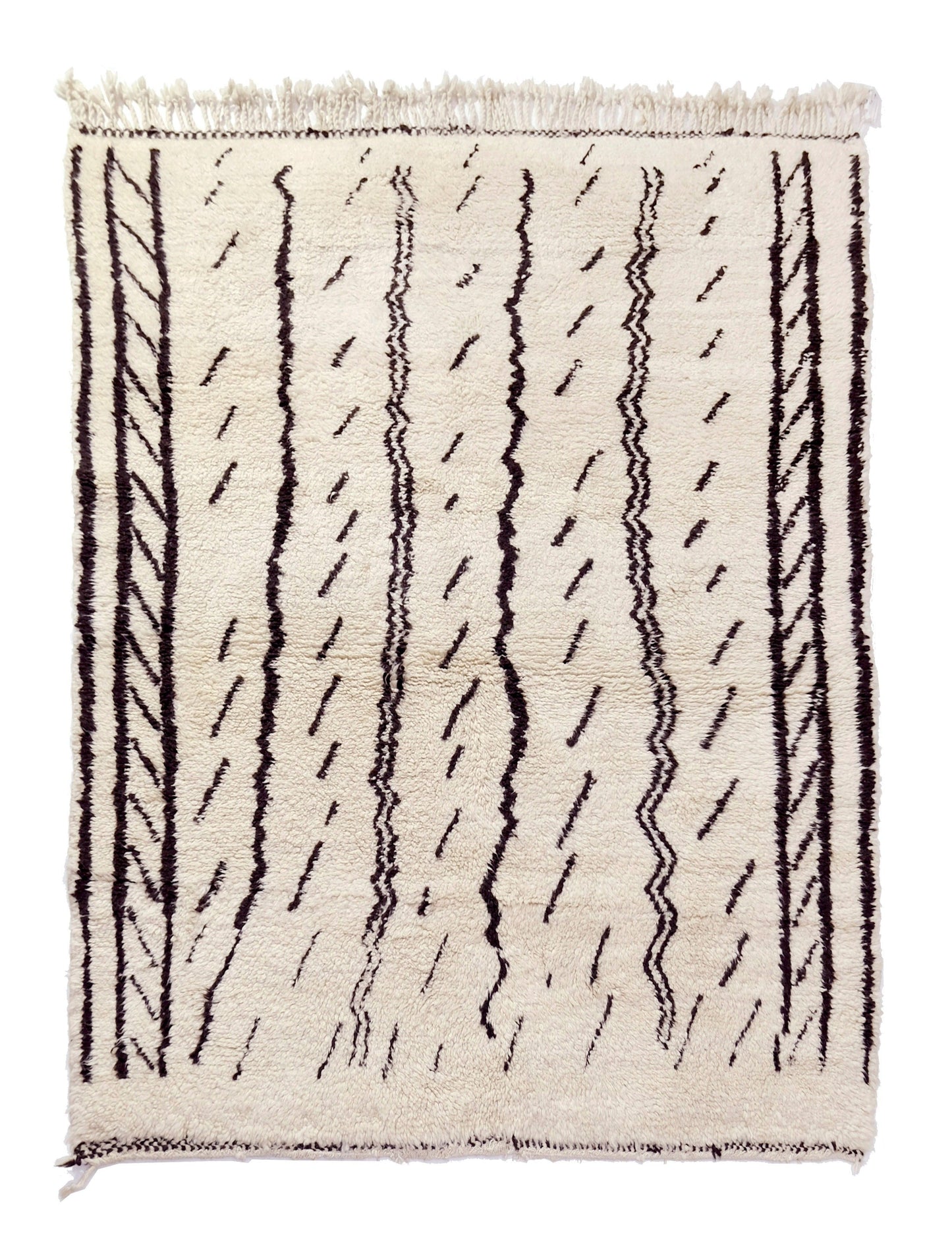 A cream-colored handwoven Moroccan shag rug featuring vertical black stripes with chevron patterns and scattered dashed lines, finished with cream fringe on the top and bottom edges.

