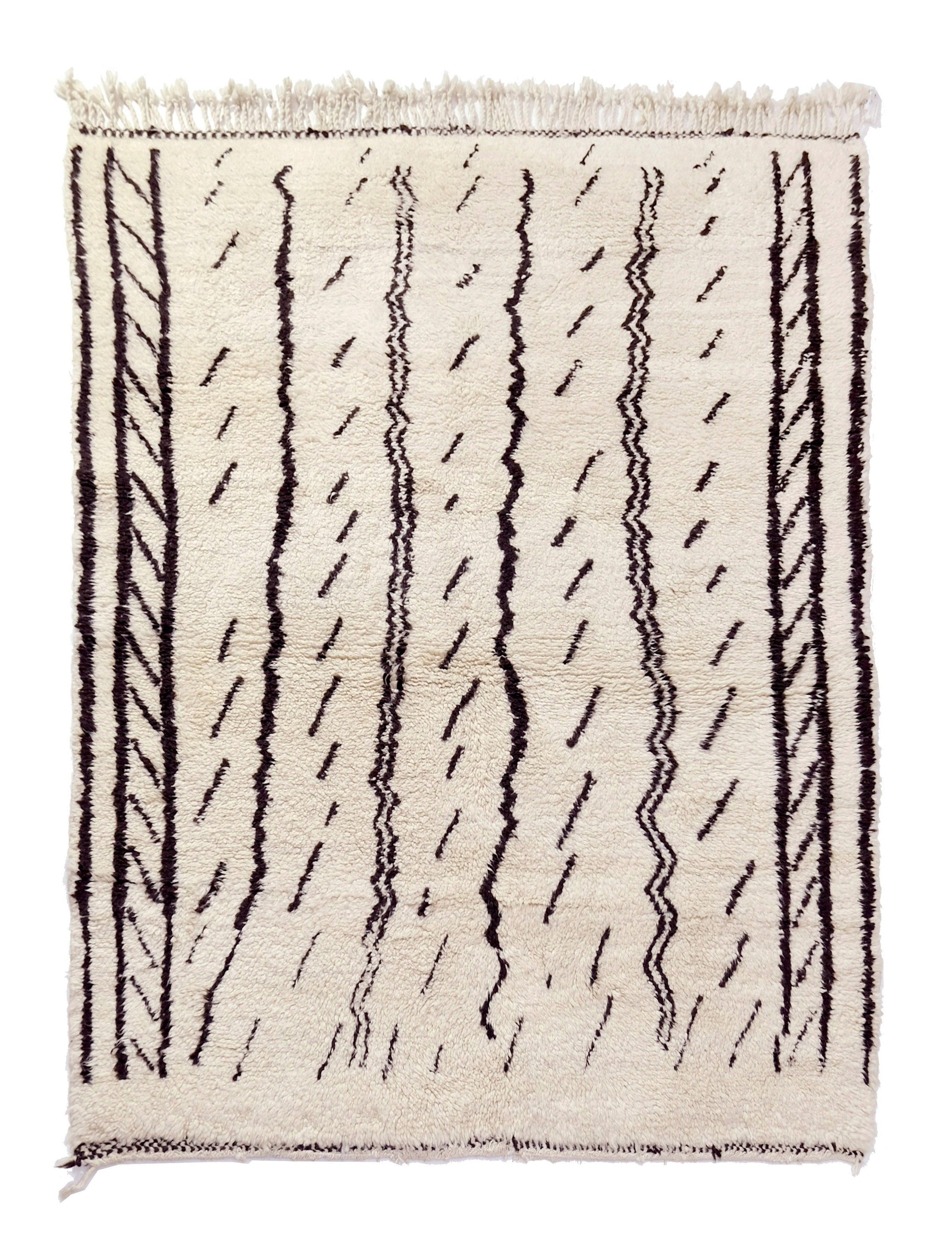 A cream-colored handwoven Moroccan shag rug featuring vertical black stripes with chevron patterns and scattered dashed lines, finished with cream fringe on the top and bottom edges.

