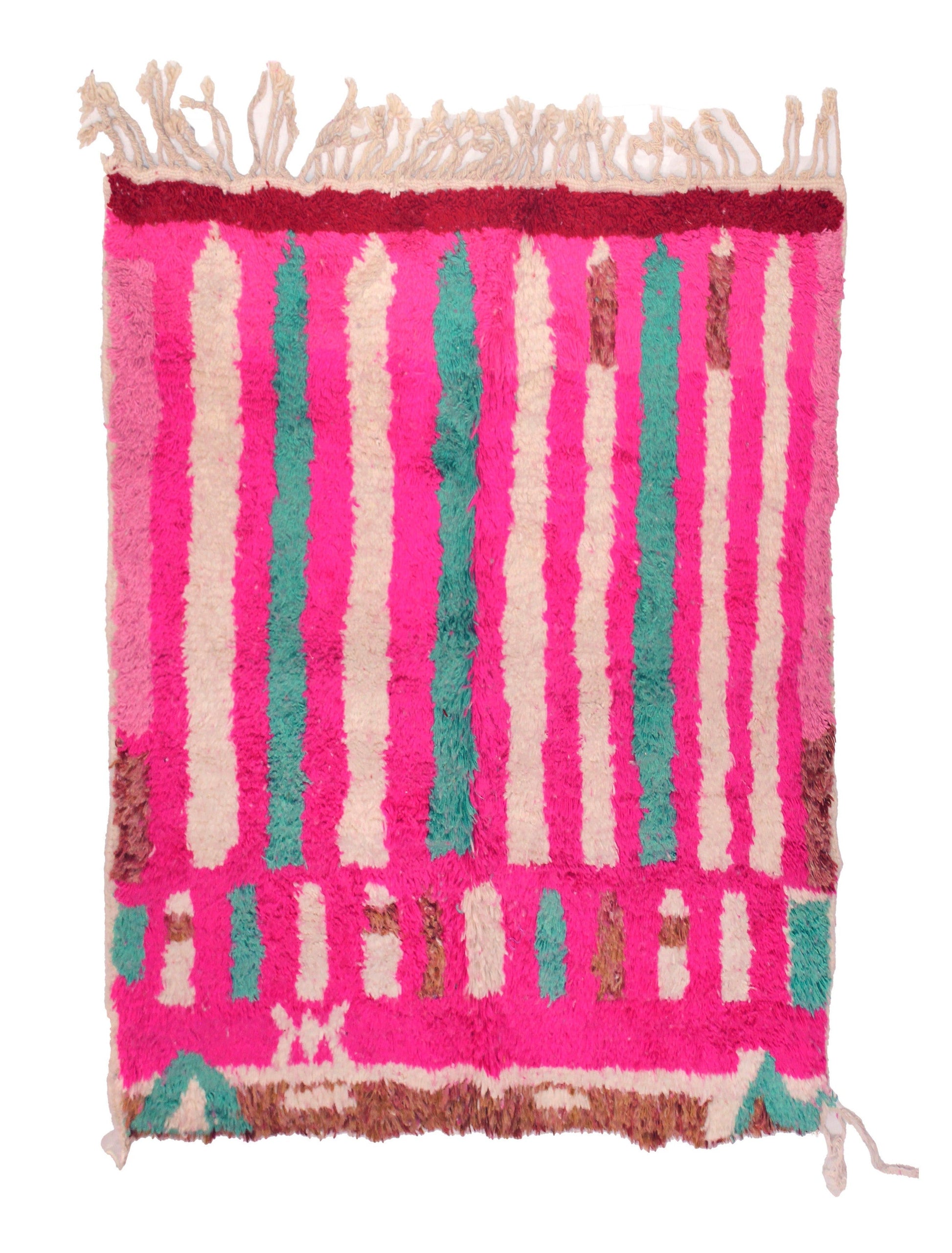 A bright pink high-pile Moroccan shag rug featuring vertical stripes in cream, teal, and brown, with a dark red border at the top and a geometric patterned section at the bottom, finished with cream fringe on the top and bottom edges.

